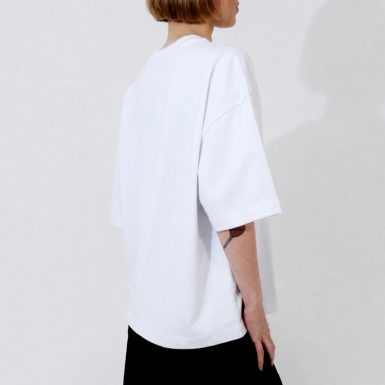 Person wearing a white t-shirt on a plain background